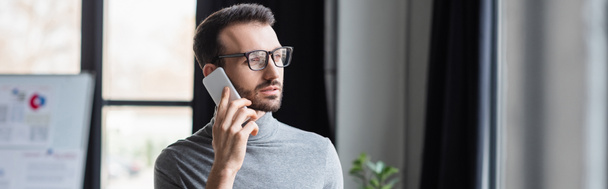 Bärtiger Geschäftsmann mit Brille im Gespräch auf Smartphone, Banner  - Foto, Bild