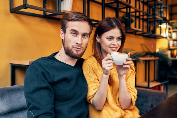 όμορφος άντρας με πουλόβερ και γυναίκα με ένα φλιτζάνι καφέ ημερομηνία αγάπη εστιατόριο καφέ - Φωτογραφία, εικόνα