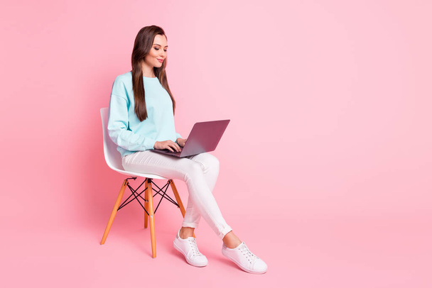 フルサイズプロフィール写真の魅力的な女性のワーキングコンピュータ上の膝の摩耗プルオーバー隔離されたピンク色の背景 - 写真・画像