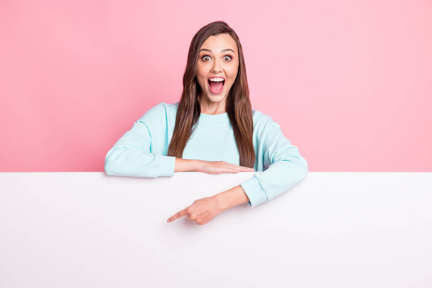 Photo of astonished lady open mouth indicate finger empty space light blue pullover isolated on pink color background - 写真・画像