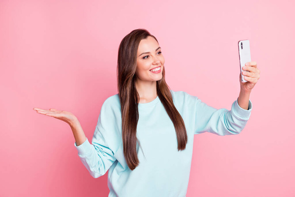 Photo of brown haired girl hold hand copyspace make selfie wear blue sweater isolated on pink color background - 写真・画像