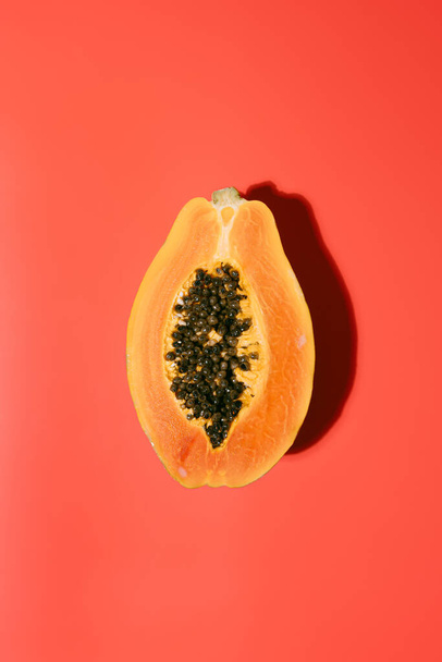 Fresh papaya with black seeds on a red background in summer. holiday and nature concept. copy space. top view - Foto, imagen