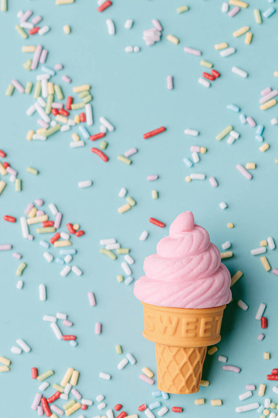 fagylalt kék háttérrel színes cukorkával megszórva. A nyár és az édesség fogalma. Illusztráció 3d. Másolás. felülnézet - Fotó, kép