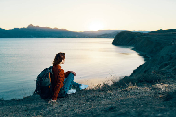 femme en vacances se reposant dans les montagnes près de la mer au coucher du soleil - Photo, image