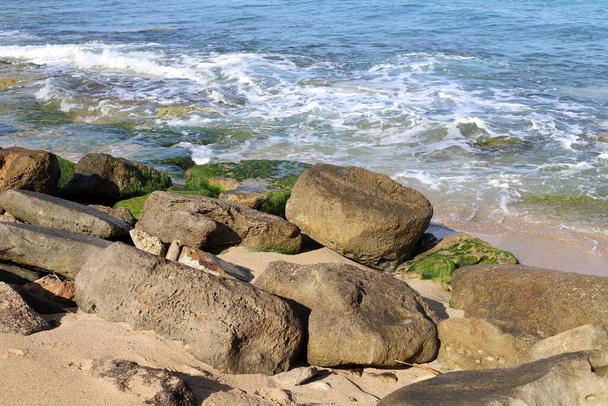 Grote stenen liggen aan de oevers van de Middellandse Zee in het noorden van Israël  - Foto, afbeelding