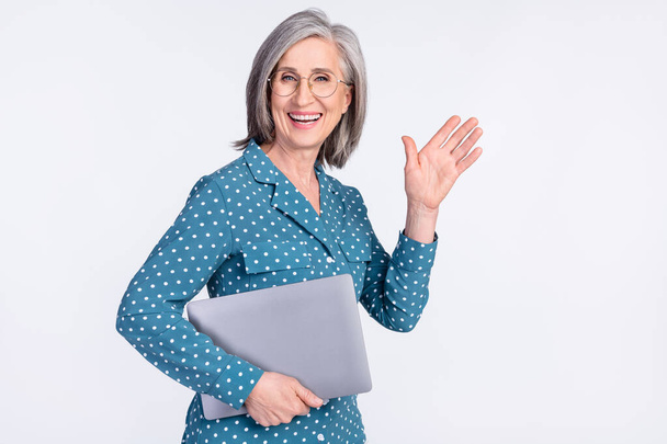 Portrait of attractive cheerful middle-aged lady carrying laptop waving hello career start isolated over gray light pastel color background - Φωτογραφία, εικόνα
