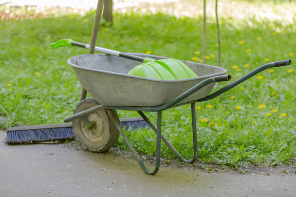 Iron wheel barrow for moving of building materials in the garden and in the backyard - Фото, зображення