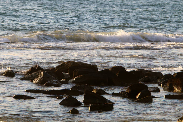 Large stones lie on the shores of the Mediterranean Sea in northern Israel  - Φωτογραφία, εικόνα
