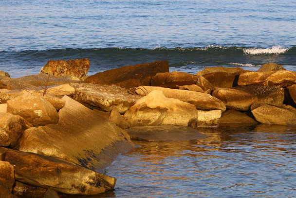 Large stones lie on the shores of the Mediterranean Sea in northern Israel  - Photo, image