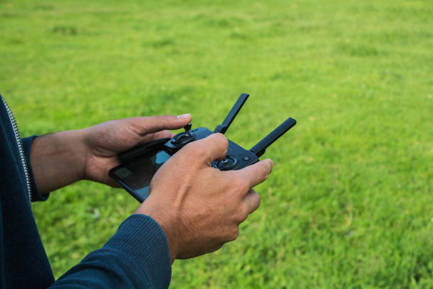 muž ovládá dálkové ovládání dronu během dne - Fotografie, Obrázek