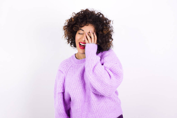  Latin nő visel pulóver teszi arcát tenyér és mosolyog széles körben, vihog pozitívan hallja vicces vicc pózok - Fotó, kép