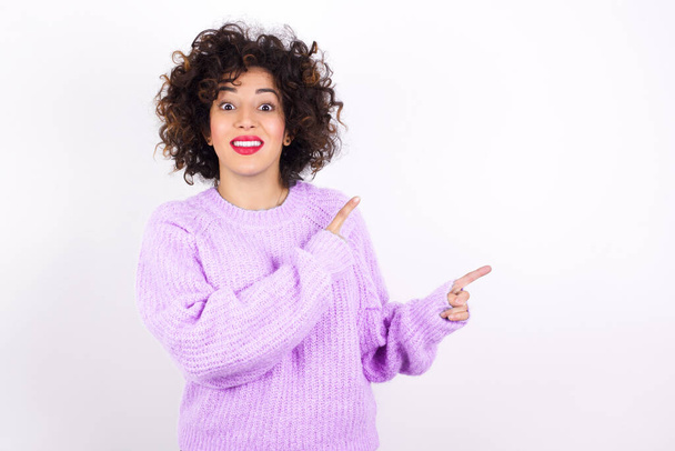 fiatal szép latin nő visel pulóver pontok másolás tér jelzi a reklám ad jó irányba - Fotó, kép