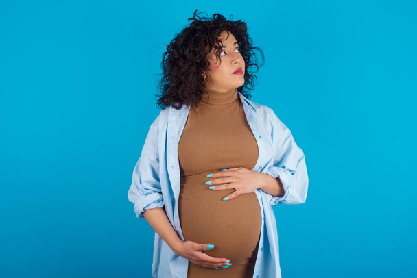   беременная арабская женщина смотрит в сторону пустого пространства вдумчивый - Фото, изображение