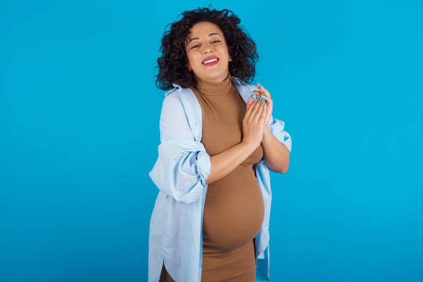 pregnant woman clapping and applauding happy and joyful, smiling proud hands together. - Foto, afbeelding
