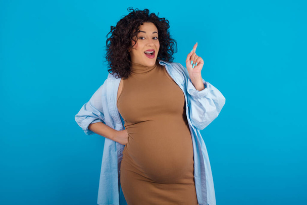   zwanger arabische vrouw houden vinger omhoog hebben idee en poseren - Foto, afbeelding