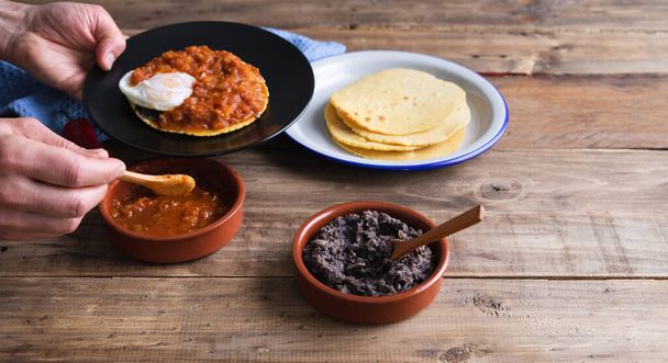 木のベースにHuevosランチェロス、メキシコの朝食を作るための成分。メキシコ料理。スペースのコピー. - 写真・画像