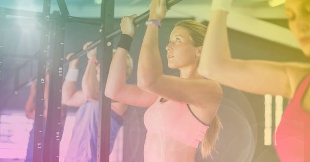 Strong women pulling up on bar exercising in gym with yellow background. healthy lifestyle, wellbeing and fitness concept digitally generated image. - Фото, изображение