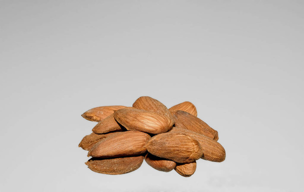 a handful of peeled almonds on a light gray background, photographed close-up - Photo, Image