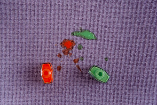Salpicadura de esmalte de uñas en tela de tapicería púrpura. vista superior - Foto, Imagen