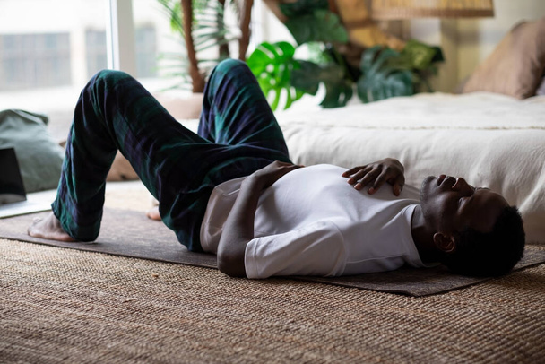 Afrikanische erwachsene Mann entspannen nach dem Training Atmung. - Foto, Bild