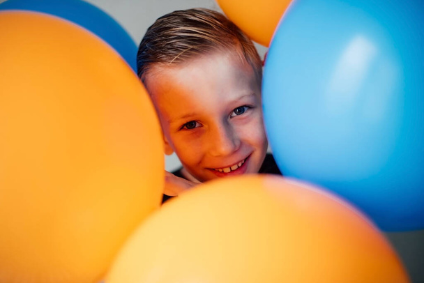 Smiling face of blond boy among balloons - Foto, Imagem