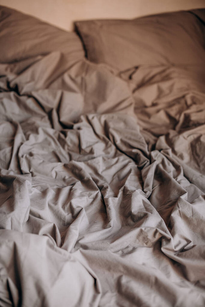 morning bed ruffled after sleep wrinkled textile blanket and pillows beig - Photo, image