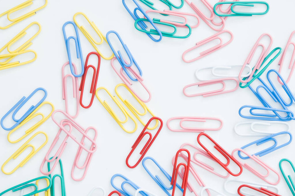 paper clips on a white background, scattered on the table. - Photo, image