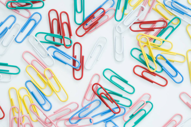 paper clips on a white background, scattered on the table. - Photo, Image