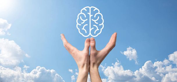 Mužská ruka drží ikonu mozku na modrém pozadí. Umělá inteligence Machine Learning Business Internet Technology Concept.Banner s kopírovacím prostorem. - Fotografie, Obrázek