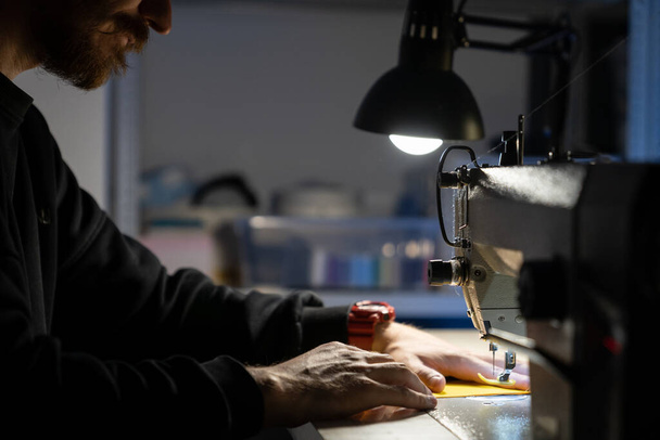 Hipster diseñador hombre coser en la máquina de coser. Trabajo creativo en estudio de sastrería o concepto de taller - Foto, Imagen