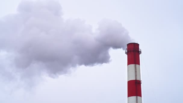 Arriba de una chimenea industrial con humo saliendo de ella, espacio para copiar, cielo gris - Metraje, vídeo