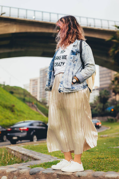 Modaya uygun giyinmiş, arka planda köprüsü olan bir feminist. Dikey resim - Fotoğraf, Görsel