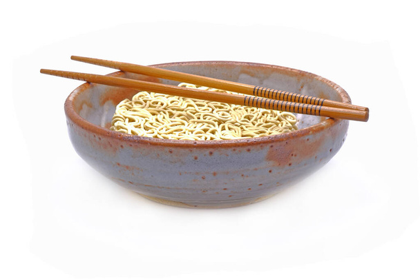 Macarrão instantâneo não cozido em tigela de estilo antigo japonês com pauzinhos de madeira. Isolado sobre fundo branco - Foto, Imagem