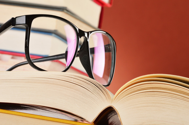 Composição com óculos e livros na mesa
 - Foto, Imagem