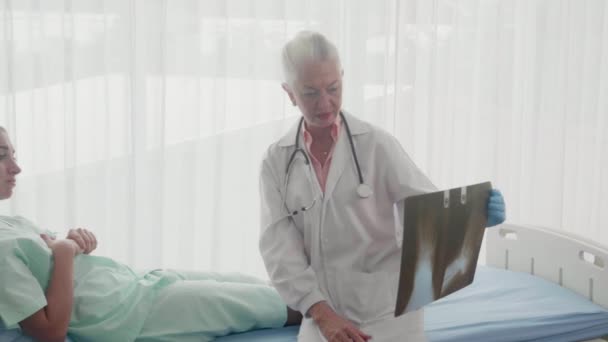 医師は、ベッドの上でX線フィルムを心配しながら、患者の負傷と骨足の病気についての専門家の診断です,病気を調べる専門知識を持つ女性,医学と医療の概念. - 映像、動画