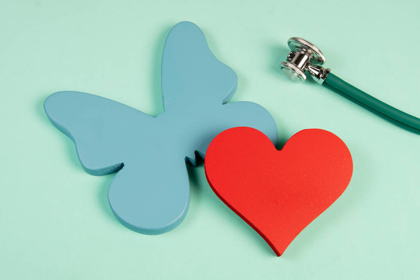 Vlinder symboliseert de schildklier en de vorm van een hart in verband met de behandeling van problemen in verband met de 2 organen - Foto, afbeelding