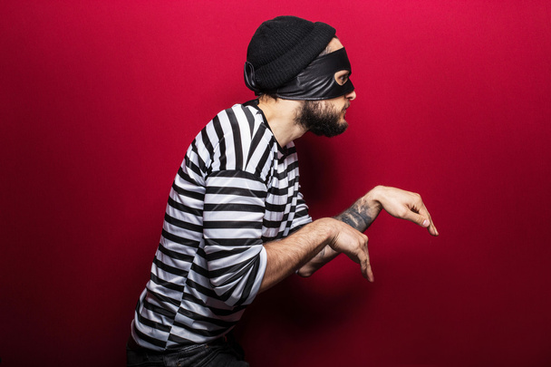 A thief with mask slinking - 写真・画像