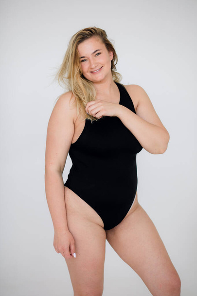 Beautiful overweight woman in black swimsuit on white background - Fotoğraf, Görsel