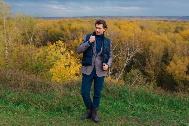 Tall handsome man outdoor in autumn forest on the hill - Foto, immagini