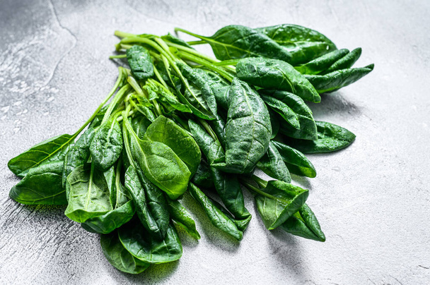 Raw fresh spinach leaves on a stone table. White background. Top view - Foto, afbeelding