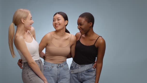 3人の幸せな多様な女性の友人が一緒に結合し、脇と自由空間を見て、カメラに笑みを浮かべて、スローモーション - 映像、動画