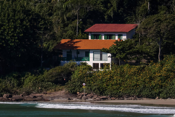 A nice old colonian luxury house in front of the ocean with native tropical vegetation as garden. - Photo, Image