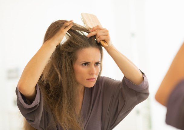 Woman combing hair in bathroom - Foto, Bild