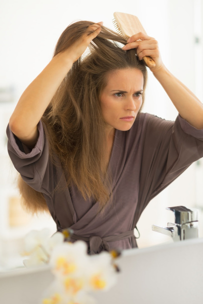 Woman combing hair in bathroom - Fotó, kép