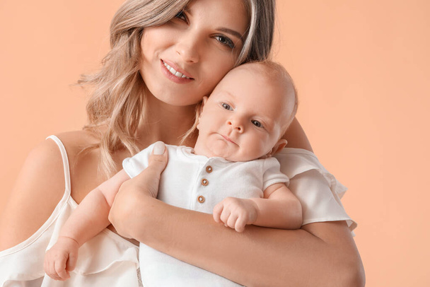 Mère heureuse avec mignon petit bébé sur fond de couleur, gros plan - Photo, image