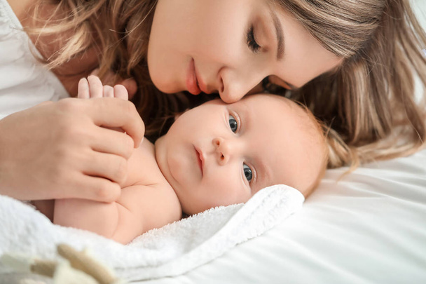 Щаслива мати і мила маленька дитина в ліжку вдома, крупним планом
 - Фото, зображення