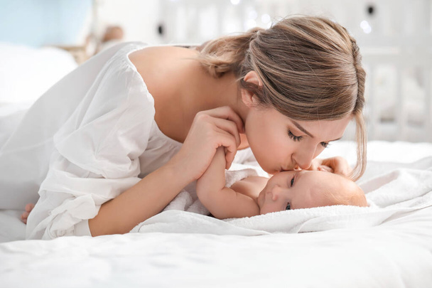 Happy mother and cute little baby on bed at home - Foto, Imagem