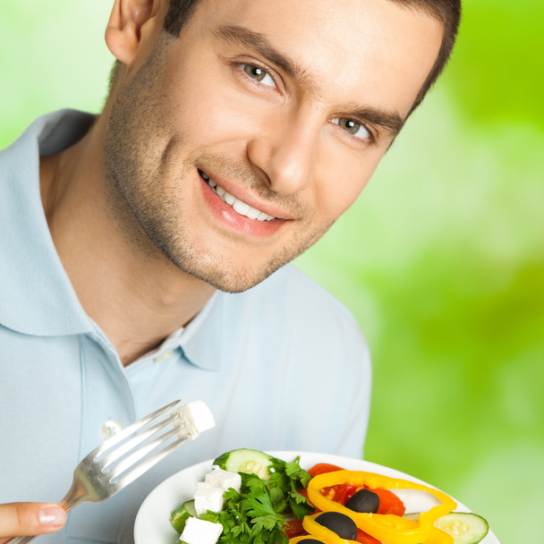 Portrait de jeune homme avec assiette de salade, extérieur
 - Photo, image