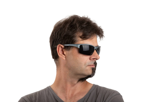 rozdwojenie osobowości - portret zwykłego czterdziestoletniego brodatego mężczyzny z półgoloną i nieogoloną twarzą w okularach przeciwsłonecznych odizolowanego na biało - Zdjęcie, obraz