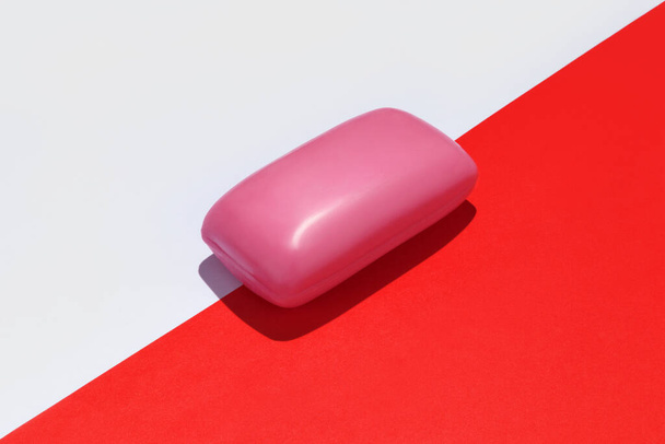 Pink soap bar on white and red background. - Zdjęcie, obraz